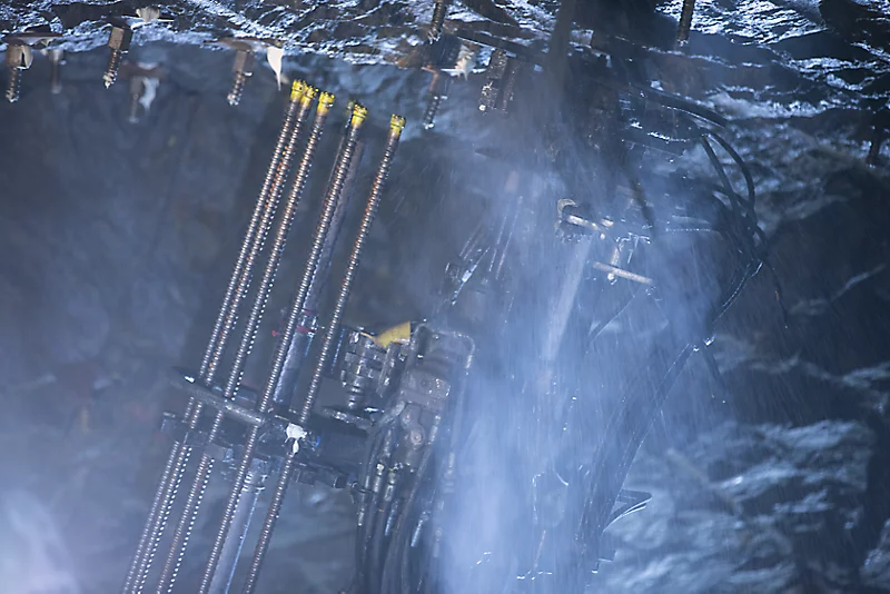 Underground drilling operation showcasing advanced mining equipment in action.