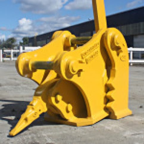 Yellow excavator attachment on a concrete surface outdoors, highlighting industrial equipment features and utility.