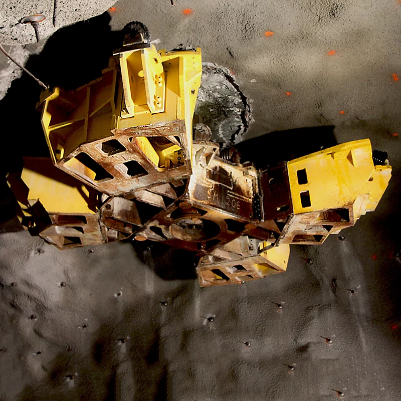 A yellow tunnel boring machine cutter head operating in an underground excavation project.